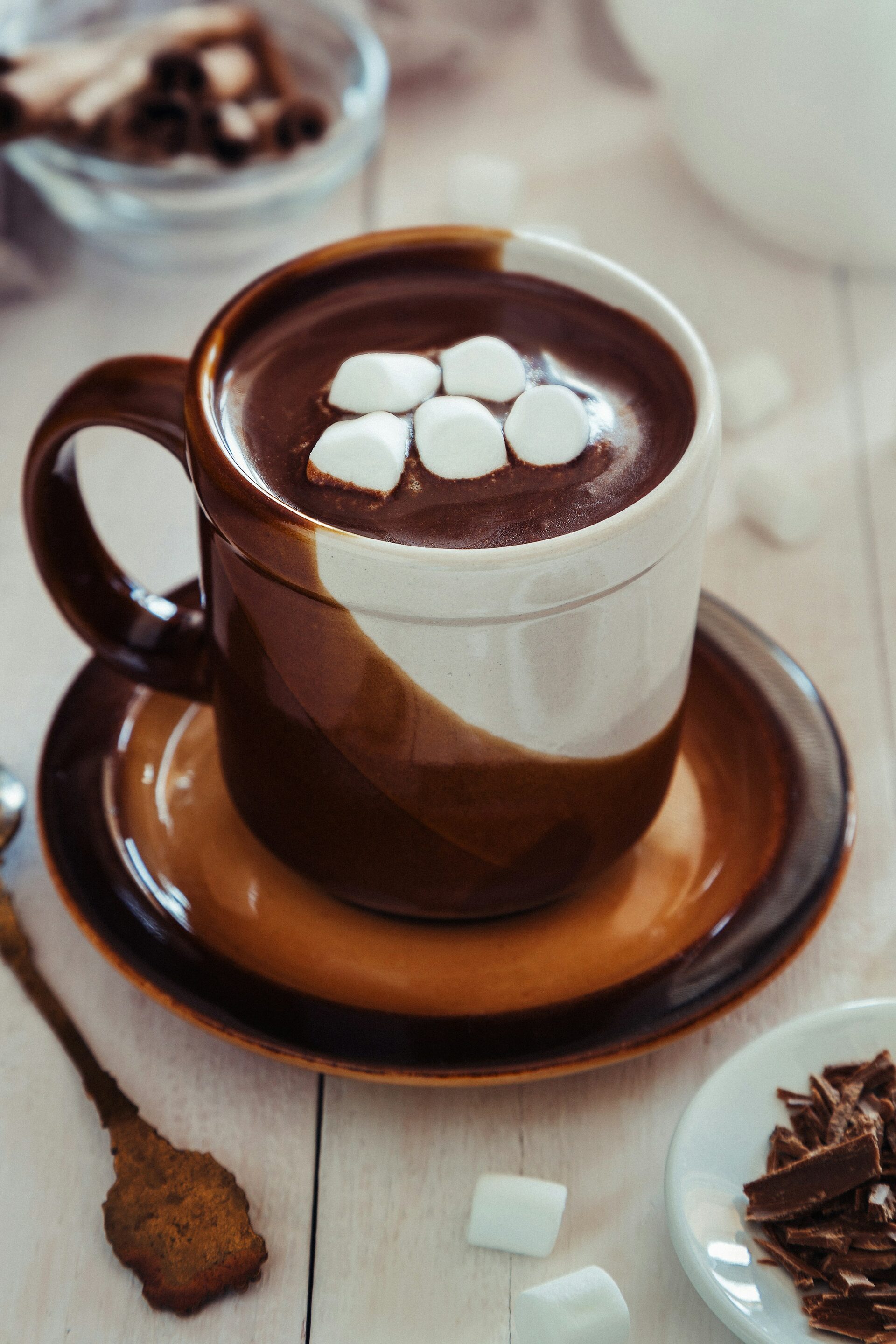 A bright, cozy cup of hot chocolate made with Cocoa Merchant cocoa powder, topped with marshmallows